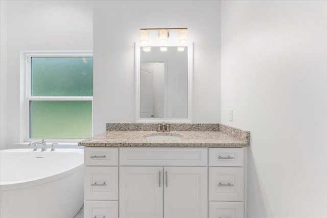 bathroom with a washtub and vanity