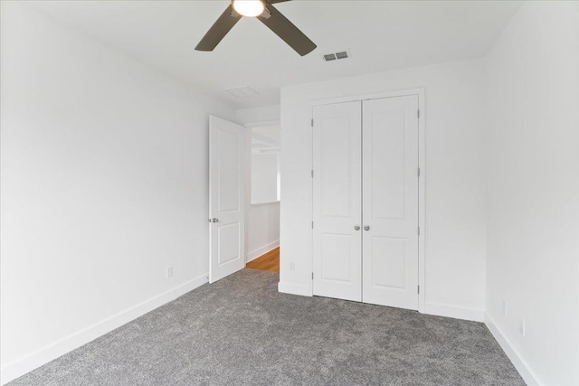 unfurnished bedroom featuring ceiling fan, a closet, and dark colored carpet