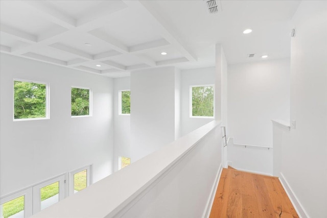 corridor with beamed ceiling, light hardwood / wood-style floors, and coffered ceiling