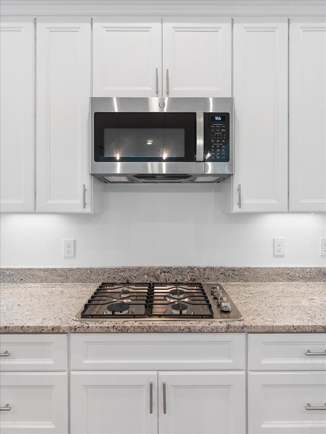 kitchen featuring white cabinets, light stone countertops, and stainless steel appliances