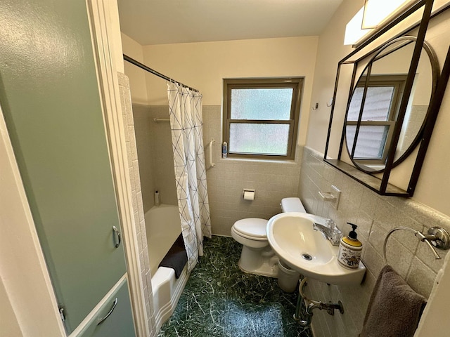 bathroom featuring wainscoting, toilet, a sink, shower / bathtub combination with curtain, and tile walls