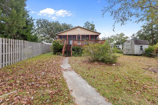 view of front of home featuring a wooden deck, a sunroom, and a storage shed