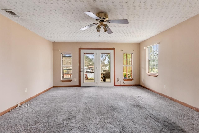 empty room with ceiling fan, a textured ceiling, and carpet flooring