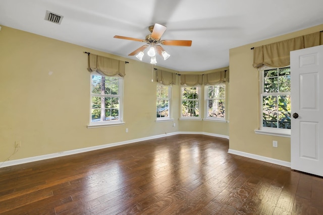 empty room featuring hardwood / wood-style floors, ceiling fan, baseboards, and visible vents