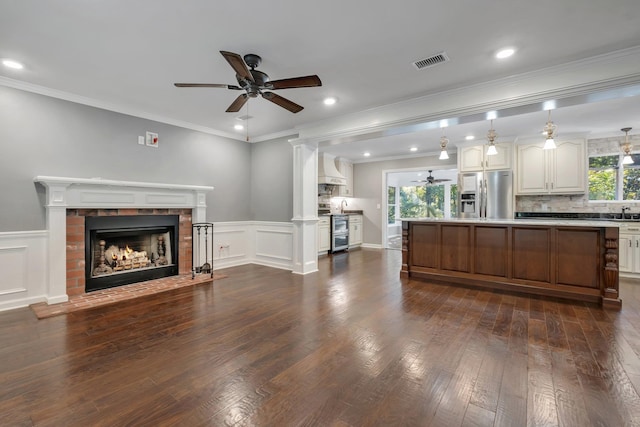 unfurnished living room featuring visible vents, ceiling fan, plenty of natural light, and a fireplace