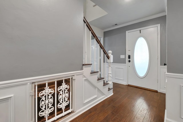entryway with crown molding, a decorative wall, visible vents, stairway, and dark wood-style flooring