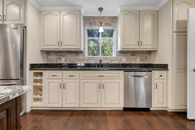 kitchen with a sink, cream cabinetry, appliances with stainless steel finishes, and dark wood-style flooring