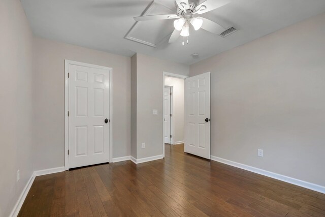 unfurnished bedroom featuring ceiling fan, visible vents, baseboards, and wood finished floors