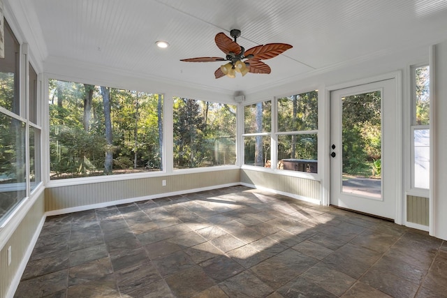 unfurnished sunroom featuring a ceiling fan and a healthy amount of sunlight