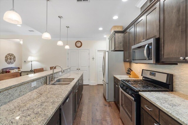 4516 Cavendish Ct, Tallahassee, FL 32309 - kitchen with appliances with stainless steel finishes, dark brown cabinetry, crown molding, decorative backsplash, and dark wood finished floors