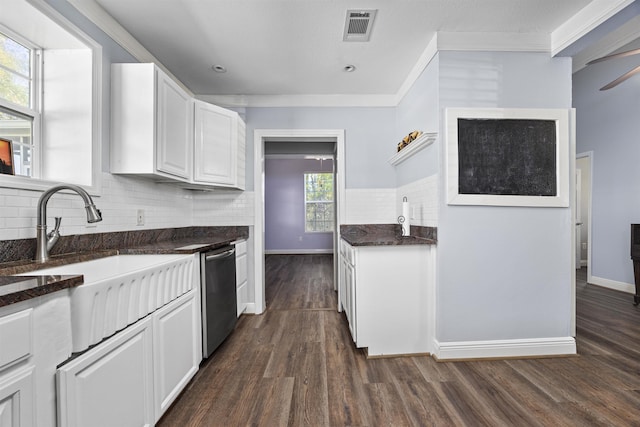 kitchen with white cabinets, dark hardwood / wood-style floors, stainless steel dishwasher, and decorative backsplash