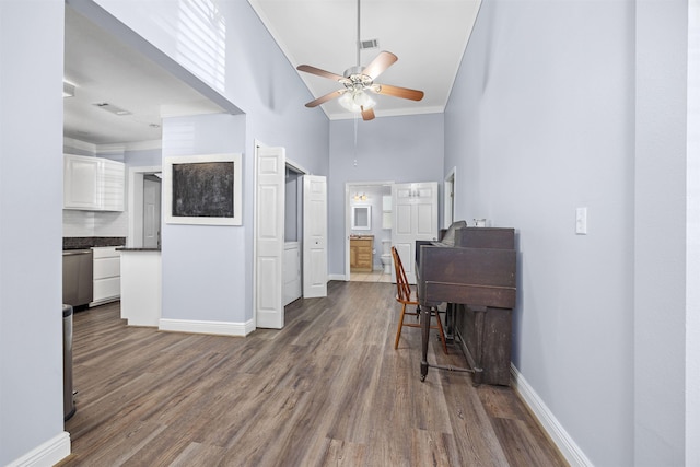 office with ceiling fan, crown molding, a towering ceiling, and dark hardwood / wood-style floors