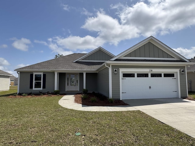 ranch-style home with board and batten siding, a garage, roof with shingles, a front yard, and concrete driveway