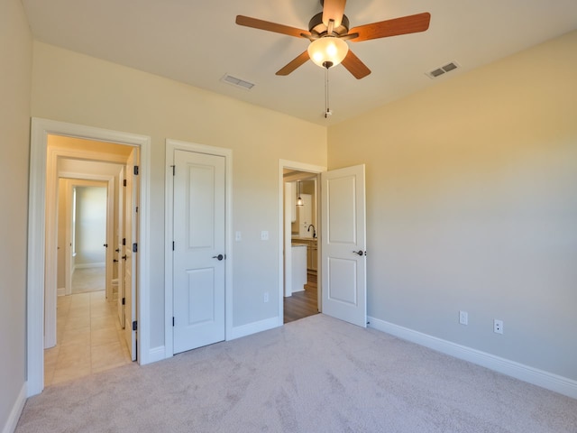 unfurnished bedroom featuring baseboards, visible vents, ceiling fan, and carpet