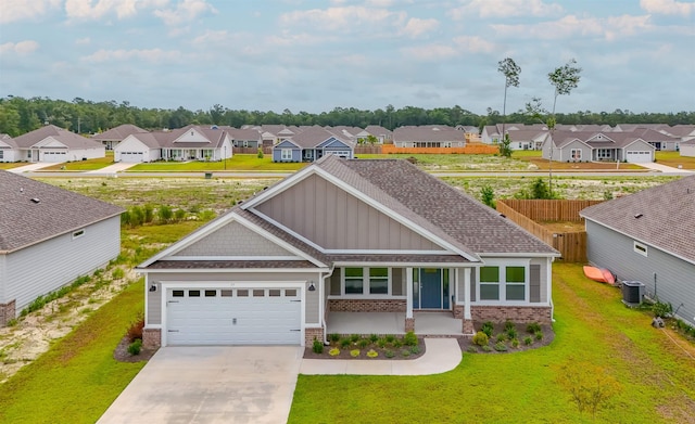 view of front of house featuring a garage, cooling unit, and a front lawn