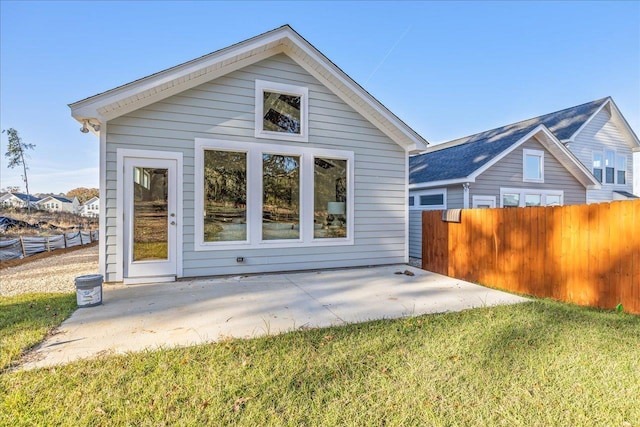 rear view of property featuring a lawn and a patio area