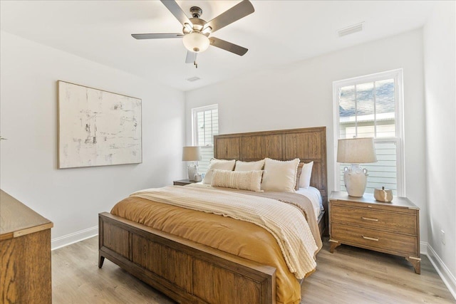 bedroom with multiple windows, light wood-type flooring, and ceiling fan