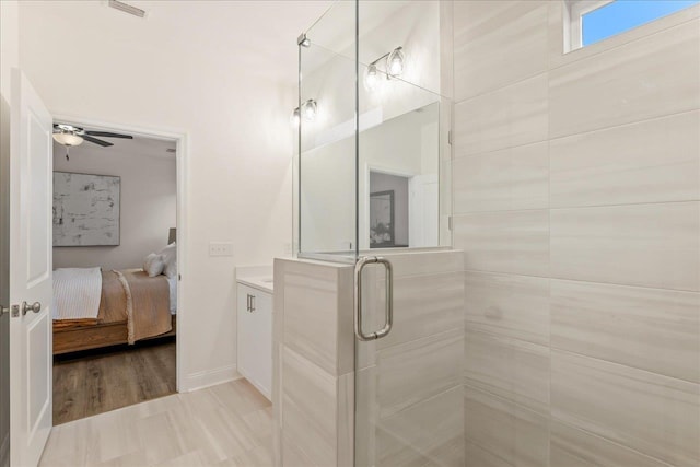 bathroom with ceiling fan, a shower with shower door, and vanity