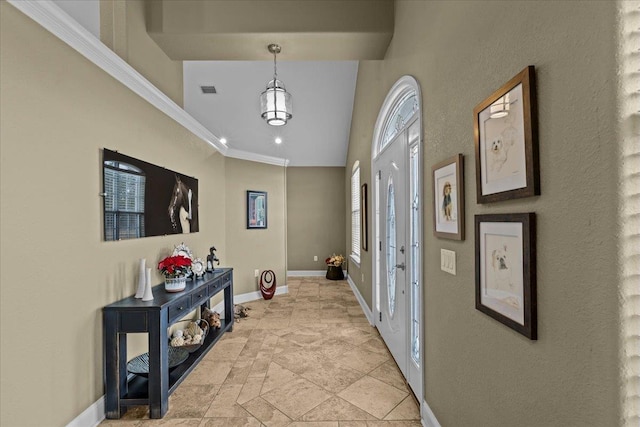 foyer featuring crown molding and vaulted ceiling