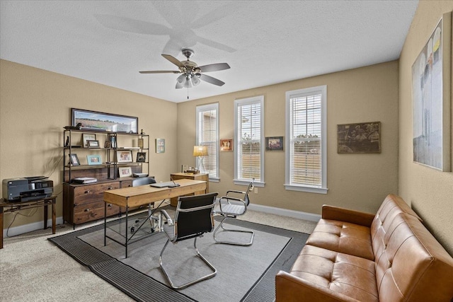 office featuring light carpet, a textured ceiling, and ceiling fan