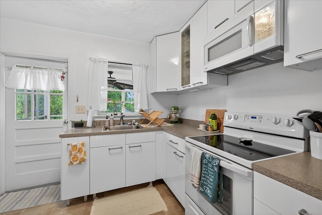 1454 S Gadsden St -, Unit Tallahassee, FL 32301 - kitchen featuring white appliances, white cabinets, dark countertops, glass insert cabinets, and a textured ceiling