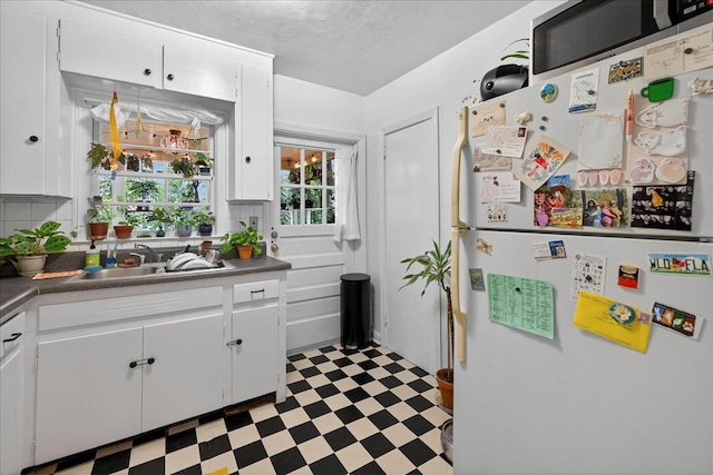 1454 S Gadsden St -, Unit Tallahassee, FL 32301 - kitchen featuring freestanding refrigerator, light flooring, white cabinets, dark countertops, and tasteful backsplash