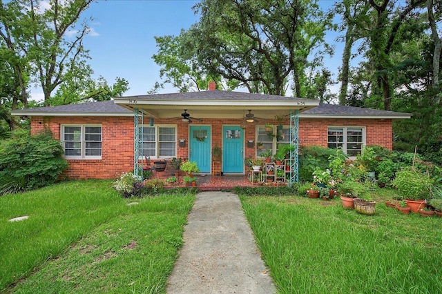 1454 S Gadsden St -, Unit Tallahassee, FL 32301 - view of front facade featuring a ceiling fan, brick siding, a front lawn, and a chimney