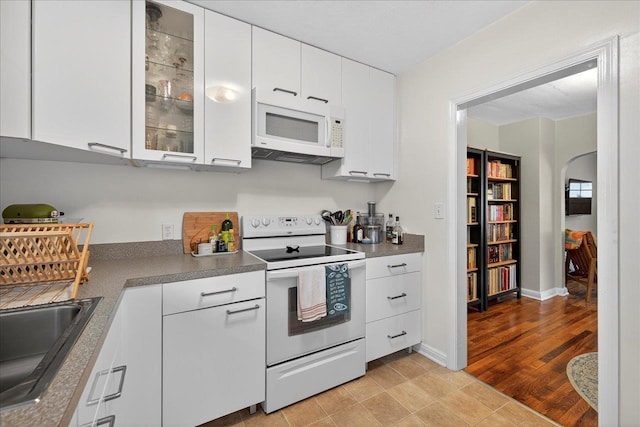 1454 S Gadsden St -, Unit Tallahassee, FL 32301 - kitchen featuring white appliances, arched walkways, white cabinets, and glass insert cabinets