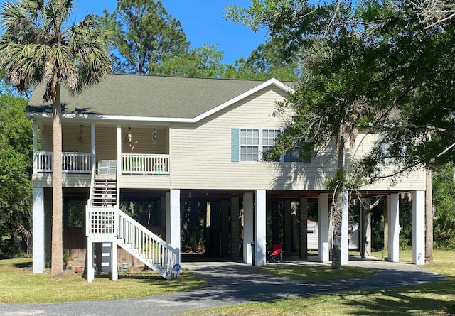 coastal home featuring a front lawn, a carport, and a porch