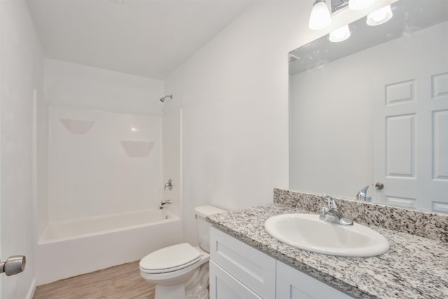 full bathroom with vanity, hardwood / wood-style flooring,  shower combination, and toilet