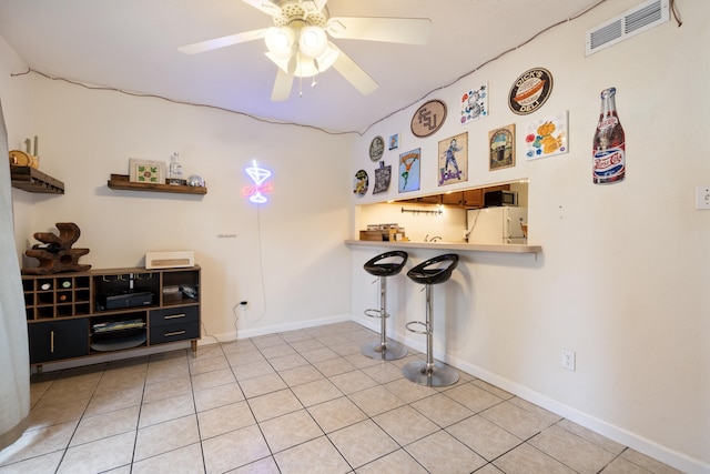 interior space with tile patterned flooring, ceiling fan, and white fridge