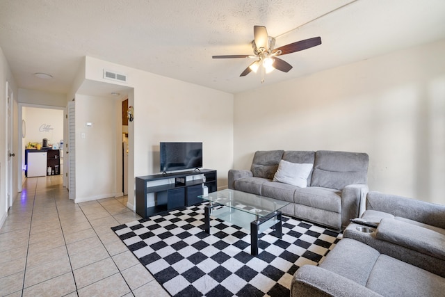 tiled living room with ceiling fan and a textured ceiling