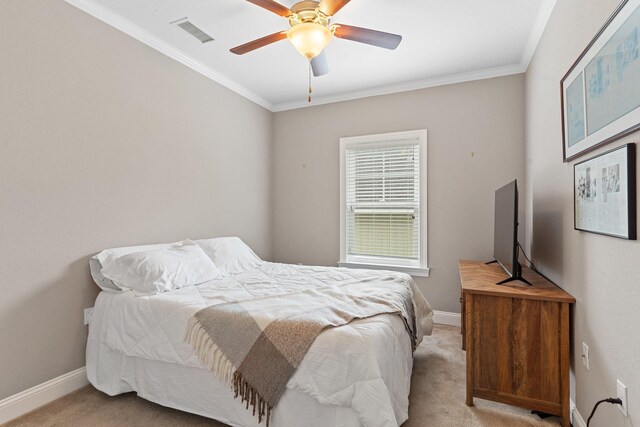 carpeted bedroom featuring ceiling fan and crown molding