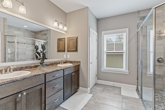 bathroom featuring tile patterned flooring, a shower with door, and vanity