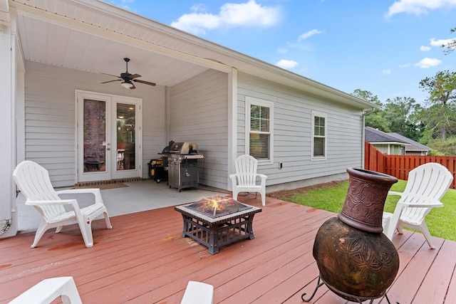 deck featuring french doors, a fire pit, area for grilling, and ceiling fan