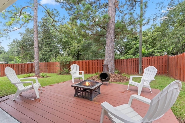 deck with a fire pit and a yard