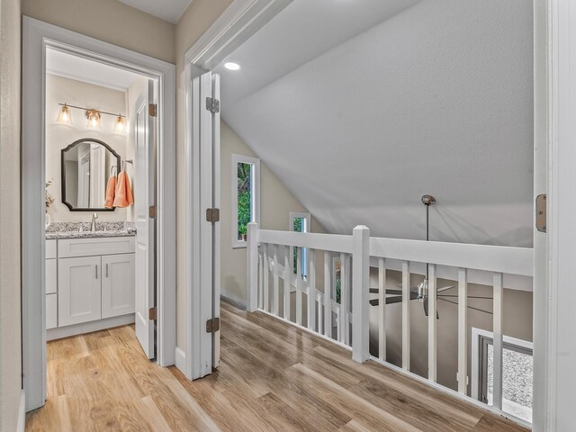 2191 Shangri La Ln E Unit 12B, Tallahassee, FL 32303 - hall featuring light wood-type flooring, vaulted ceiling, a sink, an upstairs landing, and recessed lighting