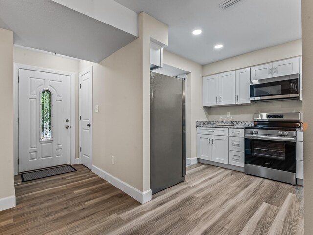 2191 Shangri La Ln E Unit 12B, Tallahassee, FL 32303 - kitchen featuring appliances with stainless steel finishes, light wood-type flooring, baseboards, white cabinets, and recessed lighting