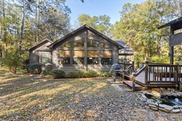 back of house with a wooden deck and a sunroom