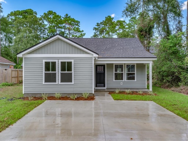 161 Broken Bow Trl, Crawfordville, FL 32327 - view of front of home with a front yard, a porch, fence, and roof with shingles