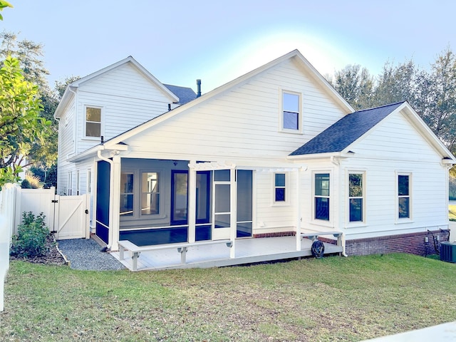 rear view of property with a sunroom and a yard