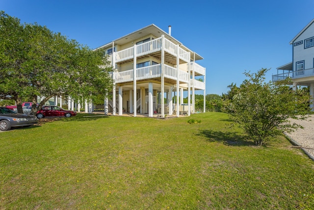 back of property with a lawn and a balcony