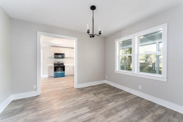 181 E Center St, Perry, FL 32348 - spare room featuring a chandelier and light wood-style floors