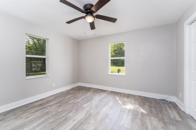 181 E Center St, Perry, FL 32348 - empty room with healthy amount of natural light, wood finished floors, and ceiling fan