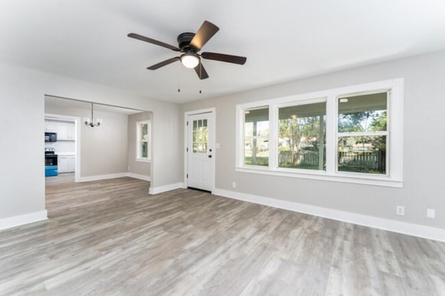 181 E Center St, Perry, FL 32348 - unfurnished living room featuring a chandelier, plenty of natural light, wood finished floors, and a ceiling fan