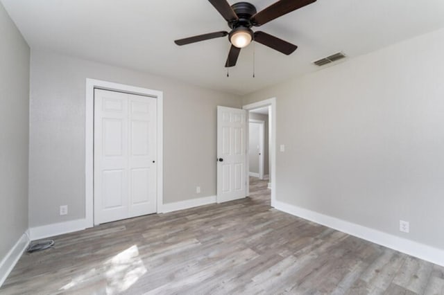 181 E Center St, Perry, FL 32348 - unfurnished bedroom featuring wood finished floors, a closet, and a ceiling fan
