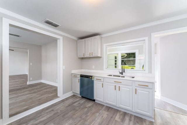 181 E Center St, Perry, FL 32348 - kitchen with dishwasher, light wood-style flooring, light countertops, white cabinetry, and ornamental molding