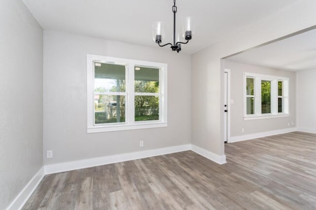 181 E Center St, Perry, FL 32348 - empty room featuring plenty of natural light, a chandelier, and wood finished floors