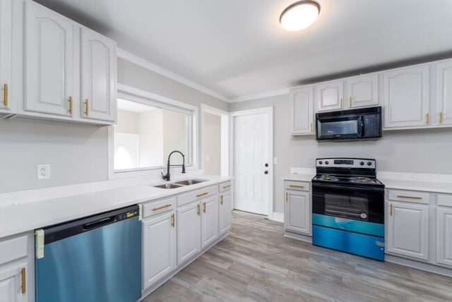 181 E Center St, Perry, FL 32348 - kitchen with black microwave, dishwashing machine, range with electric stovetop, light wood-type flooring, and white cabinetry