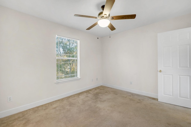 carpeted spare room featuring ceiling fan